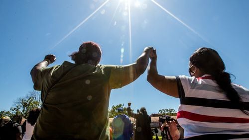 At the King Center on Sunday, April 4, 2021, the Rev. Martin Luther King Jr.'s family holds a wreath-laying ceremony on the 53rd anniversary of the assassination of the civil rights leader.  Melinda Latson of Fayettville, N.C. (left), joins hands with a stranger, Sylvia Swindell (right), who sings "We Shall Overcome" with the group. (Photo: Jenni Girtman for The Atlanta Journal-Constitution)