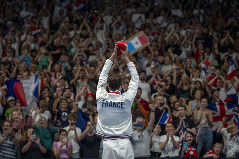 Paralympic athlete Ugo Didier, of France, celebrates at the podium after winning the Men's 400 Freestyle -S9, during the 2024 Paralympics, Thursday, Aug. 29, 2024, in Paris, France. (AP Photo/Emilio Morenatti)