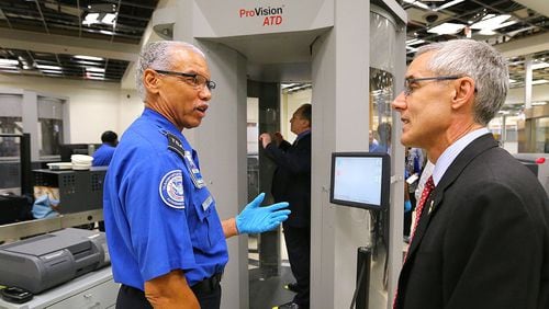 TSA Administrator Peter Neffenger, right, chats with TSA officer Garrison Brown as he passes through security after meeting with employees at Hartsfield-Jackson International Airport.