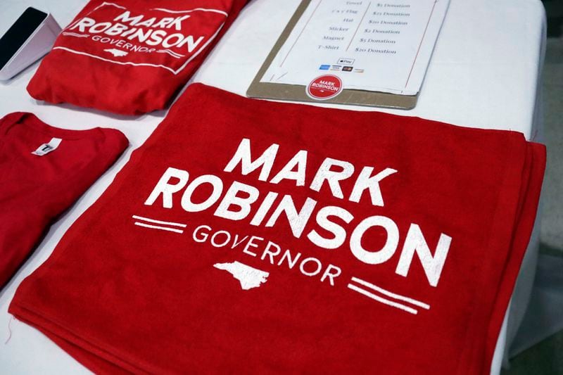 FILE - Campaign merchandise is for sale as North Carolina Lt. Gov. Mark Robinson, a Republican candidate for North Carolina governor, holds a rally Jan. 26, 2024, in Roxboro, N.C. In his bid to become North Carolina's first Black governor, Robinson assails government safety-net spending as a "plantation of welfare and victimhood" that he says has mired generations of Black people in "dependency" and poverty. But the firebrand lieutenant governor's political rise wouldn't have been possible without it. (AP Photo/Chris Seward, File)