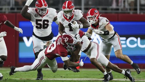 Georgia running back Trevor Etienne (1) is tackled by Alabama defensive back Malachi Moore (13) during the second quarter at Bryant-Denny Stadium, Saturday, Sept. 28, 2024, in Tuscaloosa, Al. (Jason Getz / AJC)

