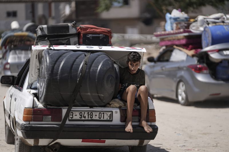 A Palestinian child rides in the trunk of a car as he evacuates Maghazi refugee camp in the central Gaza Strip, as part of a mass evacuation ordered by the Israeli military ahead of an operation, Saturday, Aug. 17, 2024. (AP Photo/Abdel Kareem Hana)