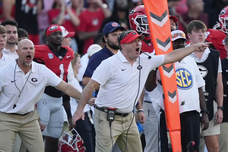 Georgia head coach Kirby Smart is restrained by another coach as he yells to his players on the field in the second half of an NCAA college football game against Auburn Saturday, Oct. 5, 2024, in Athens, Ga. (AP Photo/John Bazemore)