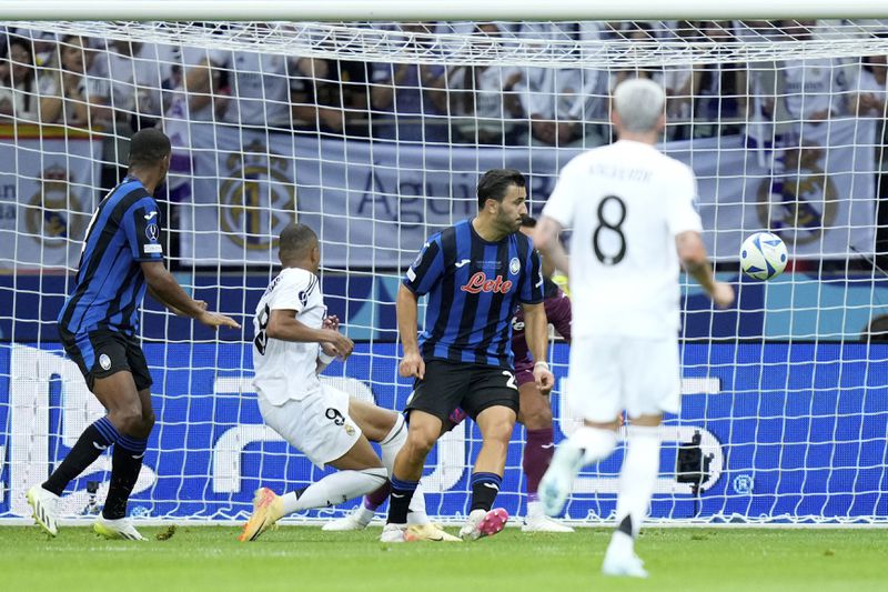 Real Madrid's Kylian Mbappe, 2nd left, scores his side's second goal during the UEFA Super Cup Final soccer match between Real Madrid and Atalanta at the Narodowy stadium in Warsaw, Poland, Wednesday, Aug. 14, 2024. (AP Photo/Darko Bandic)