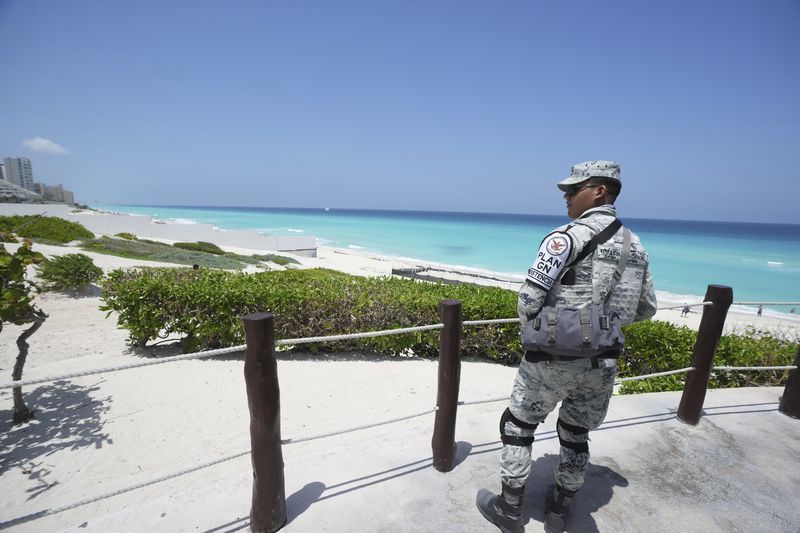 A Mexican soldier stands guard on a beach ahead of Hurricane Beryl's expected arrival, Cancun, Mexico, Wednesday, July 3, 2024. (AP Photo/Fernando Llano)