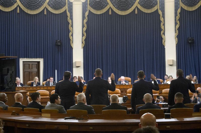 Witnesses stand to be sworn-in from left, Dr. Ariel Goldschmidt, Medical Examiner of Allegheny County, Pa. (appearing virtually), Patrick Sullivan, former U.S. Secret Service agent, Lt. John D. Herold of Pennsylvania State Police, Patrolman Drew Blasko of Butler Township Police Dept. , and Sgt. Edward Lenz of Adams Township Police Department and Commander of the Butler County Emergency Services Unit, during a House Task Force hearing on the July 13, 2024 attempted assassination of Republican presidential nominee former President Donald Trump in Butler, Pa., Thursday, Sept. 26, 2024, on Capitol Hill, in Washington. (AP Photo/Rod Lamkey, Jr.)