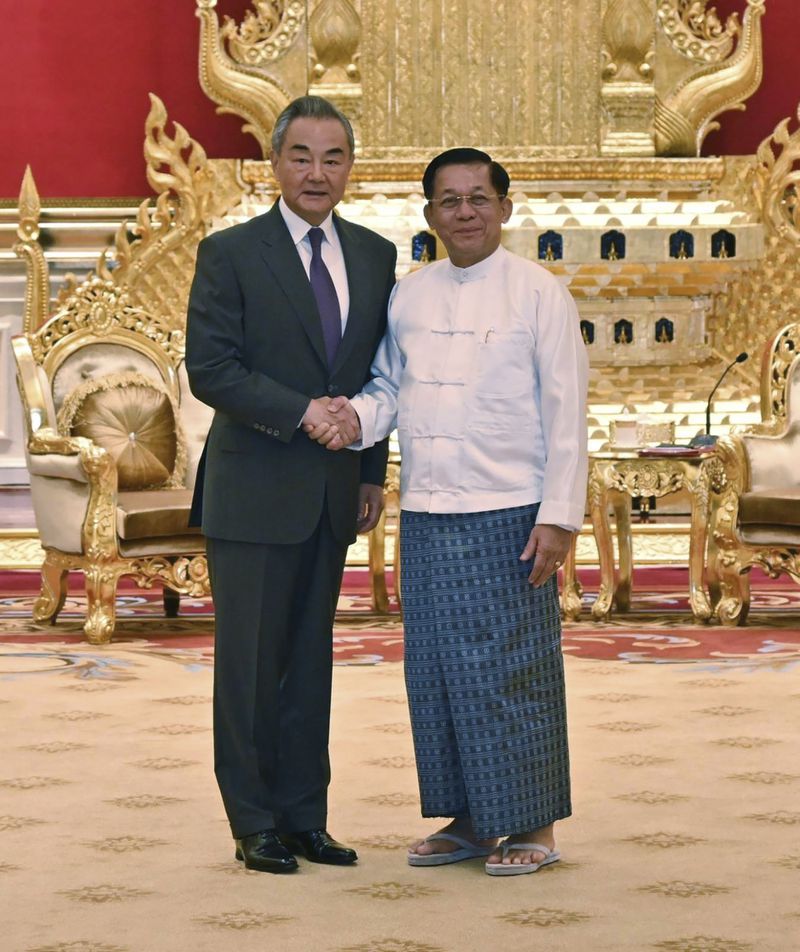 This photo provided by Myanmar Military Information Team, Myanmar's military leader Senior Gen. Min Aung Hlaing, right, chairman of State Administration Council, shakes hands with Chinese Foreign Minister Wang Yi, left, during their meeting Wednesday, Aug. 14, 2024, in Naypyitaw, Myanmar. (Myanmar Military True News Information Team via AP)