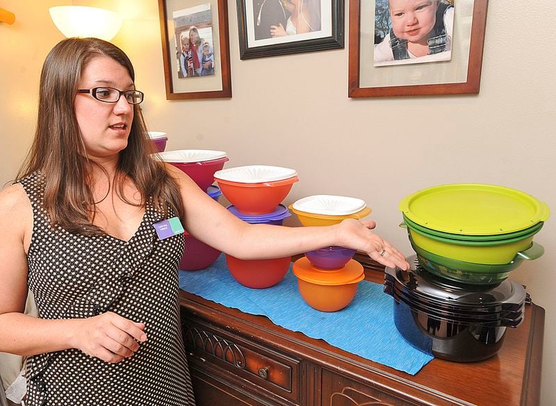 FILE - Cristina Prince, a Severna Park Elementary School teacher and a Tupperware consultant, shows off some of her merchandise on Aug. 18, 2011. (AP Photo/The Capital, Joshua McKerrow, File)