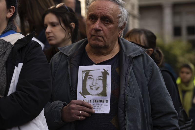 A man holds an image of Amelia Sanjurjo during her funeral service held at the University of the Republic in Montevideo, Uruguay, Thursday, June 6, 2024. The Uruguayan Prosecutor’s Office confirmed that the human remains found in June 2023 at the 14th Battalion of the Uruguayan Army belong to Sanjurjo, a victim of the 1973-1985 dictatorship who was 41 years old and pregnant at the time of her disappearance. (AP Photo/Matilde Campodonico)