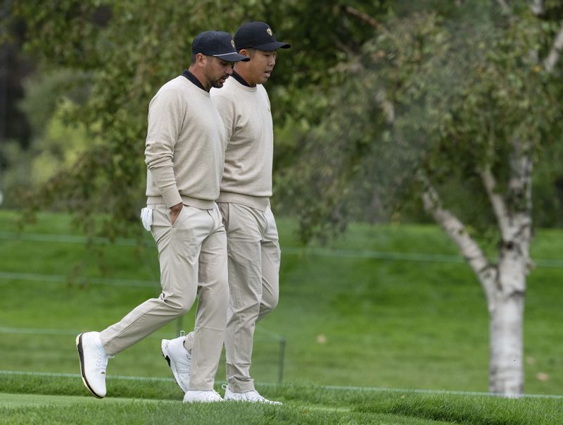 International team members Jason Day, of Australia, left, and Sungjae Im, of South Korea, walk together during practice at the Presidents Cup golf tournament at Royal Montreal Golf Club in Montreal, Tuesday, Sept. 24, 2024. (Graham Hughes/The Canadian Press via AP)