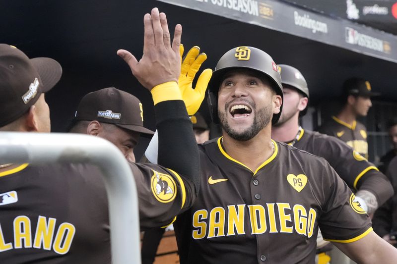 San Diego Padres' David Peralta celebrates in the dugout after hitting a two-run home run during the second inning in Game 2 of a baseball NL Division Series against the Los Angeles Dodgers, Sunday, Oct. 6, 2024, in Los Angeles. (AP Photo/Mark J. Terrill)