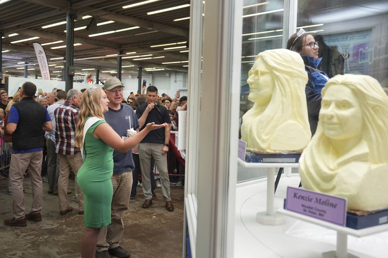 Democratic vice presidential candidate Minnesota Gov. Tim Walz visits the Minnesota State Fair and talks with 2024 Princess Kay of the Milky Way Rachel Visser of Hutchinson, in the Dairy Building Sunday, Sept. 1, 2024 in Falcon Heights, Minn. (Glen Stubbe /Star Tribune via AP)