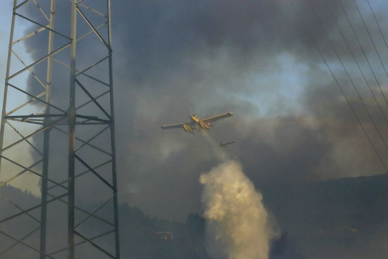 Firefighting airplanes drop water on a fire burning in Sever do Vouga, a town in northern Portugal that has been surrounded by forest fires, Monday, Sept. 16, 2024. (AP Photo/Bruno Fonseca)