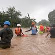 Rescuers help residents as they negotiate floods caused by powerful Typhoon Krathon locally called "Typhoon Julian" at Bacarra, Ilocos Norte province, northern Philippines on Monday, Sept. 30, 2024. (AP Photo/Bernie Dela Cruz)