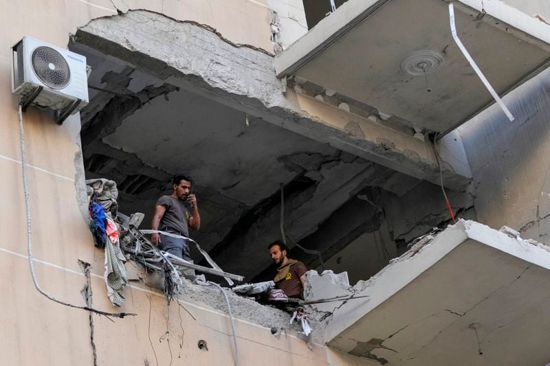 Rescuers check a building that was hit by an Israeli airstrike in Beirut's southern suburbs, Thursday, Sept. 26, 2024. (AP Photo/Hassan Ammar)