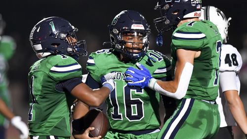 Teammates react to a touchdown by quarterback Braylan Ford (16) in the first half of play Friday, September 15, 2023. (Photo by Daniel Varnado/For the AJC)