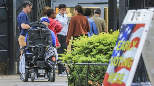 Early voters lined up before the doors opened Monday at the Buckhead Library at 269 Buckhead Ave. NE in Atlanta. JOHN SPINK/JSPINK@AJC.COM