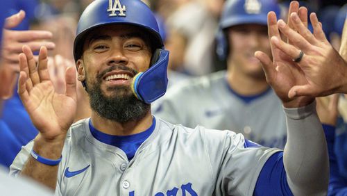 Los Angeles Dodgers' Teoscar Hernández celebrates in the dugout after Freddie Freeman hit a three-run home run in the seventh inning of a baseball game against the Atlanta Braves, Monday, Sept. 16, 2024, in Atlanta. (AP Photo/Jason Allen)