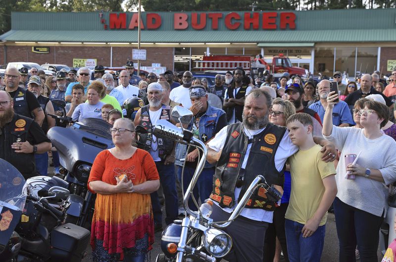 Mourners gather for a candlelight vigil in the parking lot of the Mad Butcher grocery store in honor of the victims of Friday's mass shooting in Fordyce, Ark., Sunday, June 23, 2024. (Colin Murphey/Arkansas Democrat-Gazette via AP)