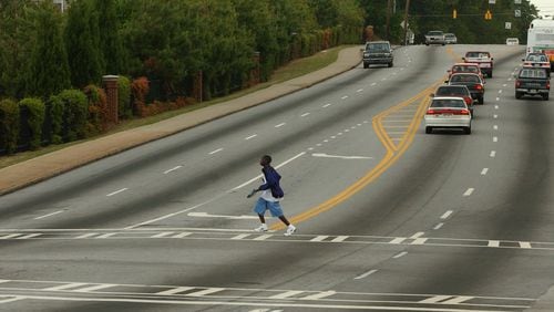 A man runs across Glenwood Road at East Lake Boulevard on his way  home from school on April 21, 2005.