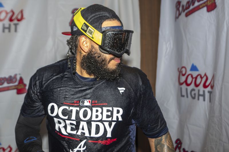 Atlanta Braves pitcher Daysbel Hernández celebrates in the locker room after clinching a wild-card playoff berth after the second baseball game of a doubleheader against the New York Mets, Monday, Sept. 30, 2024, in Atlanta. (AP Photo/Jason Allen)