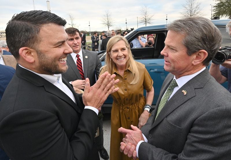 Jimmy Knauf (left), EVP of Facilities at Rivian, smiles as he shows Rivian R1T electric truck to Georgia Gov. Brian Kemp and First Lady Marty Kemp during a press conference at Liberty Plaza across from the Georgia State Capitol in Atlanta on Thursday, Dec. 16, 2021. Electric vehicle maker Rivian on Thursday confirmed its plans to build a $5 billion assembly plant and battery factory in Georgia, which Gov. Brian Kemp called "the largest single economic development project ever in this state's history." (Hyosub Shin / Hyosub.Shin@ajc.com)