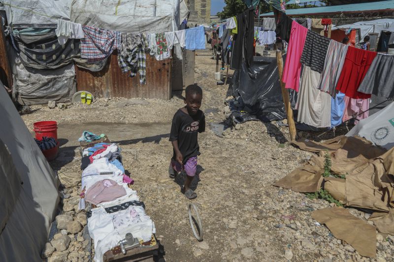 A youth plays with a ring at the end of a wire inside a school where people displaced by gang violence have taken refuge in Port-au-Prince, Haiti, Friday, Sept. 20, 2024. (AP Photo/Odelyn Joseph)