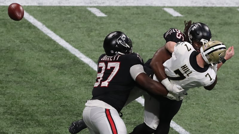 Falcons Grady Jarrett (left) and Steven Means hit New Orleans Saints quarterback Taysom Hill forcing a fumble the Falcons recovered during the fourth quarter Sunday, Dec. 6, 2020, at Mercedes-Benz Stadium in Atlanta. (Curtis Compton / Curtis.Compton@ajc.com)