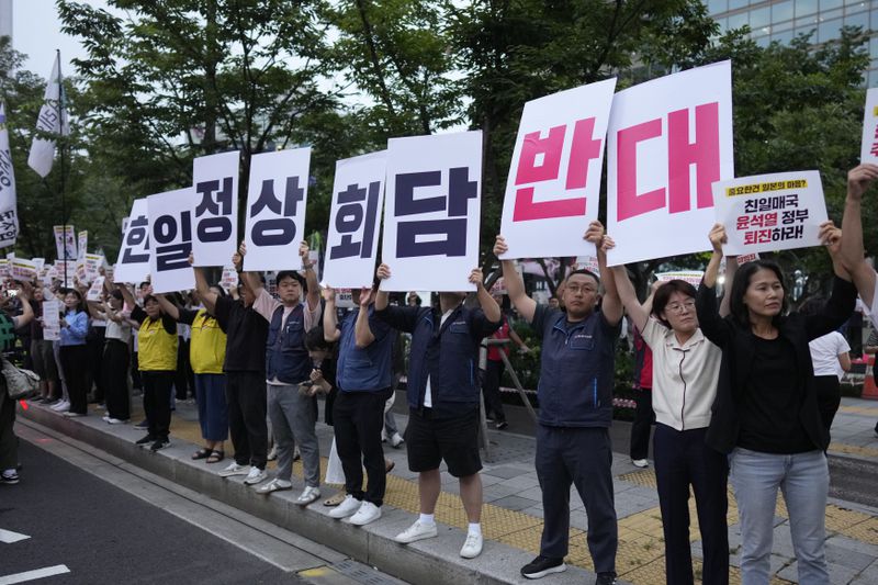 Protesters hold signs reading "Oppose the meeting between South Korea and Japan," during a rally opposing the meeting between South Korean President Yoon Suk Yeol and Japanese Prime Minister Fumio Kishida in Seoul, South Korea, Friday, Sept. 6, 2024. (AP Photo/Lee Jin-man)