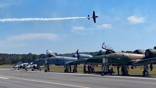 FILE/One of the Airshow Racing Series aircraft flies above the QYON Aerosports team and the A-10 Warthogs during the 2022 Wings Over North Georgia air show at Richard B. Russell Regional Airport.