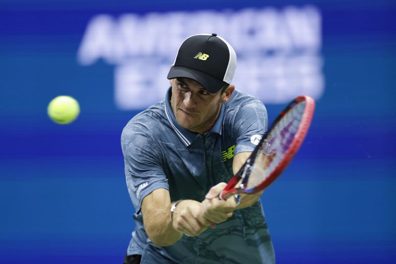 Tommy Paul, of the United States, returns a shot against Jannik Sinner, of Italy, during a fourth round match of the U.S. Open tennis championships, Monday, Sept. 2, 2024, in New York. (AP Photo/Adam Hunger)