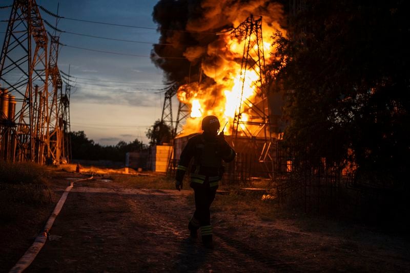 A Ukrainian firefighter talks on the radio while he works to extinguish the fire on the site of an electrical substation that was hit by Russian strike in Dnipropetrovsk region, Ukraine, Monday, Sept. 2, 2024. (AP Photo/Alex Babenko)