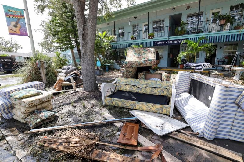 Contents of rooms are emptied on the street after flooding from Hurricane Helene on Friday, Sept. 27, 2024, in Gulfport, Fla. (AP Photo/Mike Carlson)