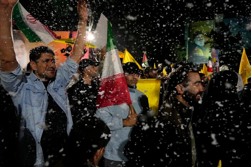 Demonstrators cheer as artificial snow sprayed in an anti-Israeli gathering celebrating Iran's missile strike against Israel, at Felestin (Palestine) Sq. in Tehran, Iran, Tuesday, Oct. 1, 2024. (AP Photo/Vahid Salemi)