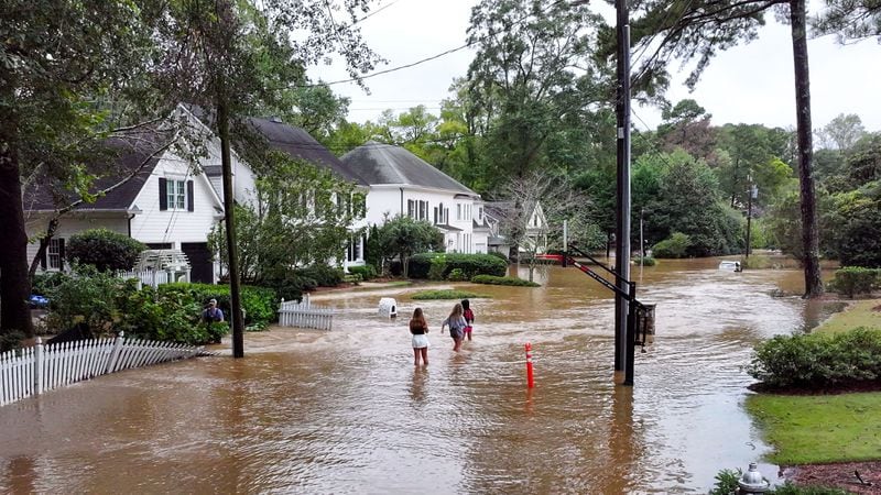 Teenagers walk down on a flooded street in Atlanta's Hanover West neighborhood on Friday, Sept. 27, 2024, in the aftermath of heavy rain from Hurricane Helene.
(Miguel Martinez / AJC)