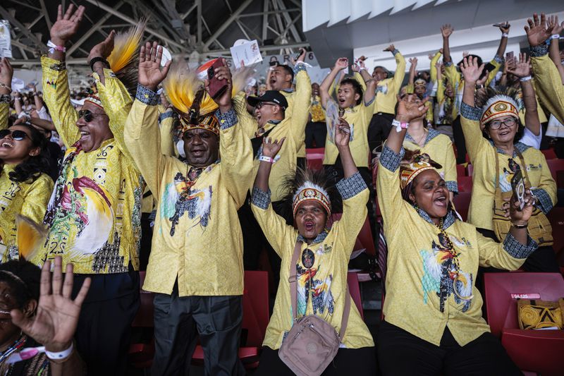 People react as they wait for the arrival of Pope Francis before a holy mass at the Gelora Bung Karno Stadium in Jakarta, Thursday, Sept. 5, 2024. (Yasuyoshi Chiba/Pool Photo via AP)