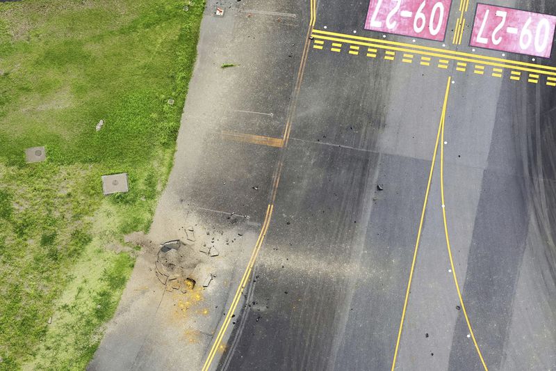 This photo taken from a Kyodo News helicopter shows part of a damaged taxiway, center, at Miyazaki Airport in southwestern Japan, Wednesday, Oct. 2, 2024, after an explosion was reported. (Kyodo News via AP)