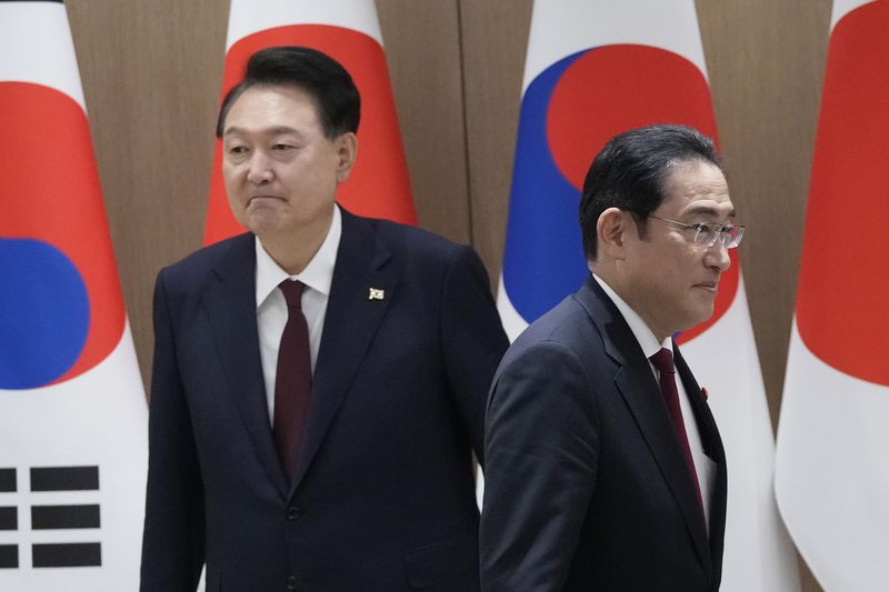 South Korean President Yoon Suk Yeol, left, and Japanese Prime Minister Fumio Kishida move their positions during a meeting at the Presidential Office in Seoul, South Korea, Sunday, May 26, 2024. (AP Photo/Ahn Young-joon, Pool)