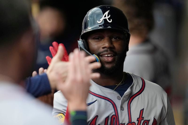 Atlanta Braves' Michael Harris II celebrates in the dugout after hitting a 2-run home run during the first inning of a baseball game against the Minnesota Twins, Tuesday, Aug. 27, 2024, in Minneapolis. (AP Photo/Abbie Parr)