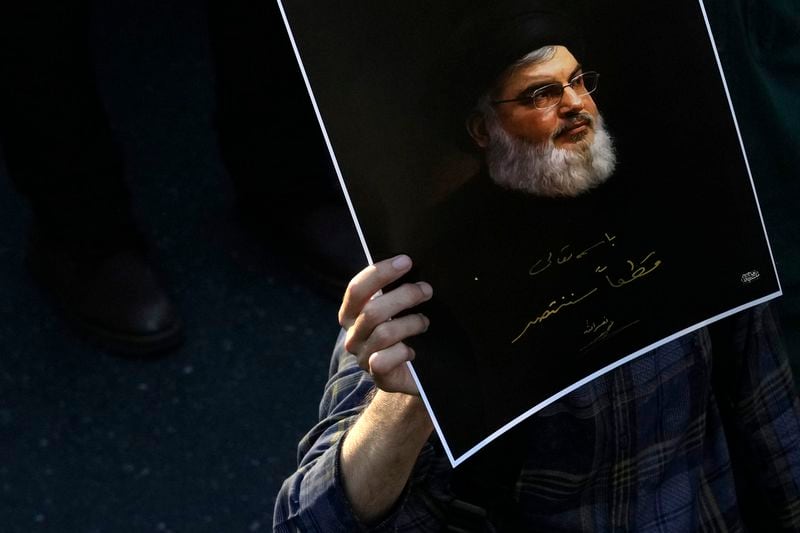 A mourner holds up a poster of slain Hezbollah leader Hassan Nasrallah with a quotation of him: "We will definitely win" at Enqelab-e-Eslami (Islamic Revolution) St. in downtown Tehran, Iran, Monday, Sept. 30, 2024. (AP Photo/Vahid Salemi)