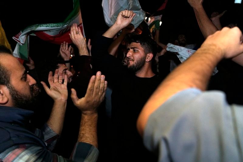 Demonstrators celebrate Iran's missile strike against Israel during an anti-Israeli gathering in front of the British Embassy in Tehran, Iran, Tuesday, Oct. 1, 2024. (AP Photo/Vahid Salemi)