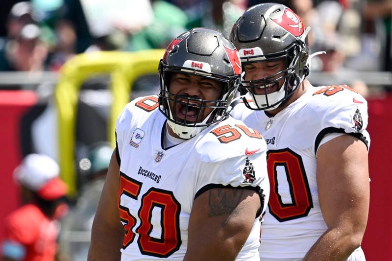 Tampa Bay Buccaneers' Vita Vea, left, and Logan Hall react after Vea sacked Philadelphia Eagles' Jalen Hurts during the first half of an NFL football game, Sunday, Sept. 29, 2024, in Tampa, Fla. (AP Photo/Jason Behnken)