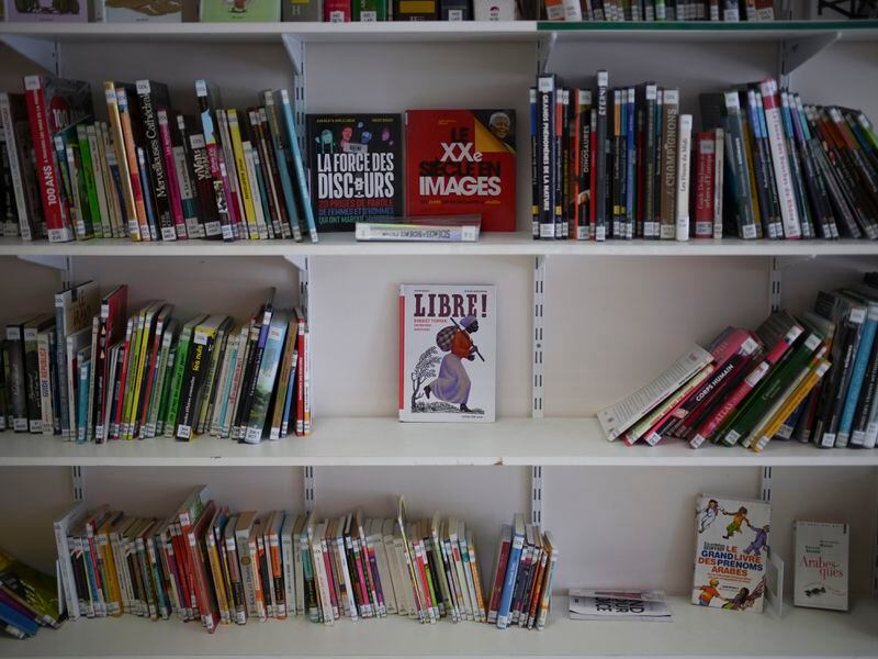 Books, including one on Harriet Tubman, are displayed in the library at Ibn Khaldoun, a private Muslim school, in Marseille, southern France, Tuesday, April 16, 2024. (AP Photo/Daniel Cole)