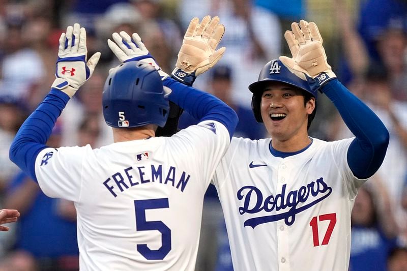 Los Angeles Dodgers' Freddie Freeman, left, is congratulated by Shohei Ohtani after hitting a three-run home run during the first inning of a baseball game against the Arizona Diamondbacks Wednesday, July 3, 2024, in Los Angeles. (AP Photo/Mark J. Terrill)