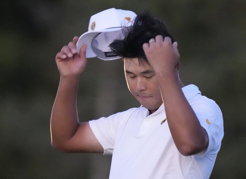 International team member Si Woo Kim of South Korea, reacts after missing his putt on the 18th hole during their fourth round foursomes match at the Presidents Cup golf tournament at Royal Montreal Golf Club Saturday, Sept. 28, 2024 in Montreal. (Frank Gunn/The Canadian Press via AP)