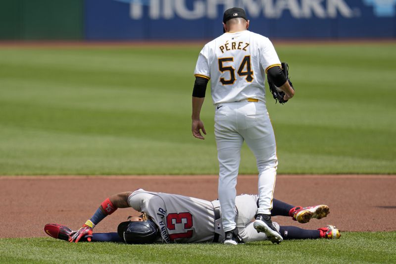 Pittsburgh Pirates starting pitcher Martín Pérez (54) checks on Atlanta Braves' Ronald Acuña Jr. who injured himself running the bases during the first inning of a baseball game against the Pittsburgh Pirates in Pittsburgh, Sunday, May 26, 2024. Acuna Jr. left the game. (AP Photo/Gene J. Puskar)