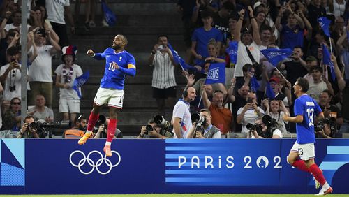 France's Alexandre Lacazette, left, celebrates after scoring his side's first goal during the men's Group A soccer match between France and the United States at the Velodrome stadium, during the 2024 Summer Olympics, Wednesday, July 24, 2024, in Marseille, France. (AP Photo/Daniel Cole)