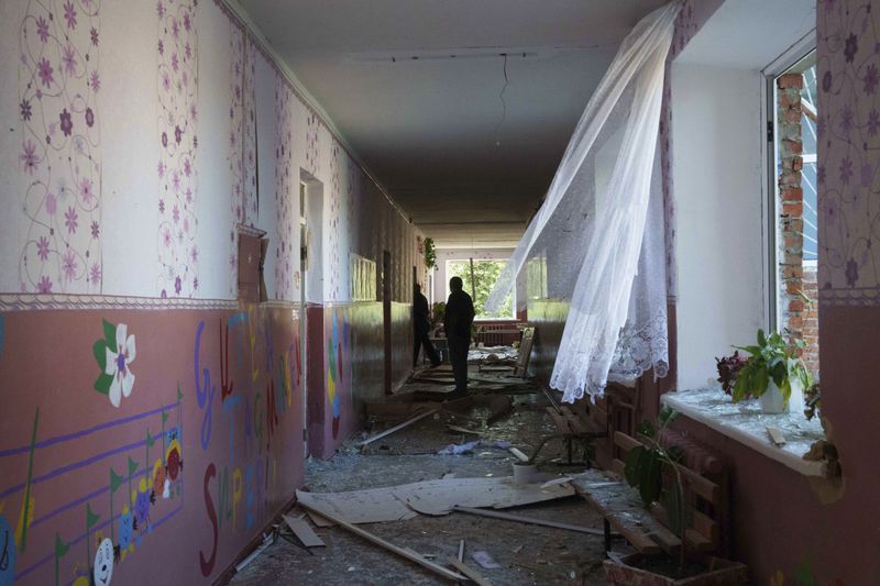 Serhii Zaichenko, 63, school guard walks in the corridor of his school which was heavily damaged after Russian airstrike in Mohrytsia, near Russian-Ukrainian border, Sumy region, Ukraine, Wednesday, Aug. 14, 2024. Zaichenko said two people were killed, including one child. (AP Photo/Evgeniy Maloletka)