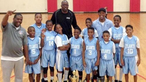 Officer Stanley Lawrence, in black, coached youth basketball as part of a police department league. He's shown with a team in this 2014 photo.