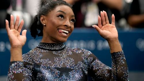 Simone Biles, of United States, celebrates after competing on the uneven bars during a women's artistic gymnastics qualification round at Bercy Arena at the 2024 Summer Olympics, Sunday, July 28, 2024, in Paris, France. (AP Photo/Charlie Riedel)
